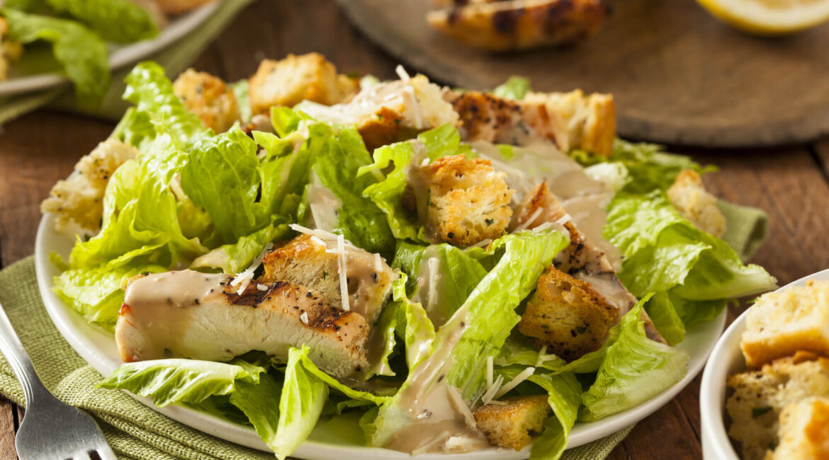A plate of salad with chicken and lettuce.